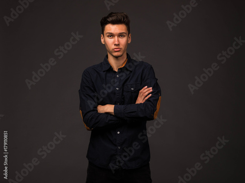 Young confident man portrait of a businessman on a black background. Ideal for banners, registration forms, presentation, landings, presenting concept.