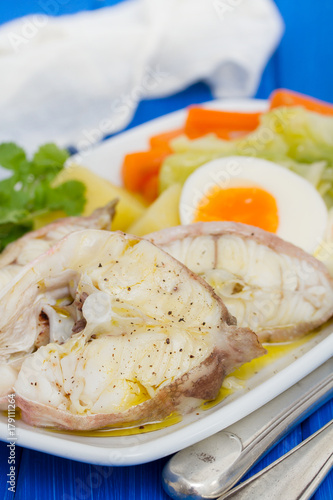 boiled fish with boiled vegetables and egg on white plate