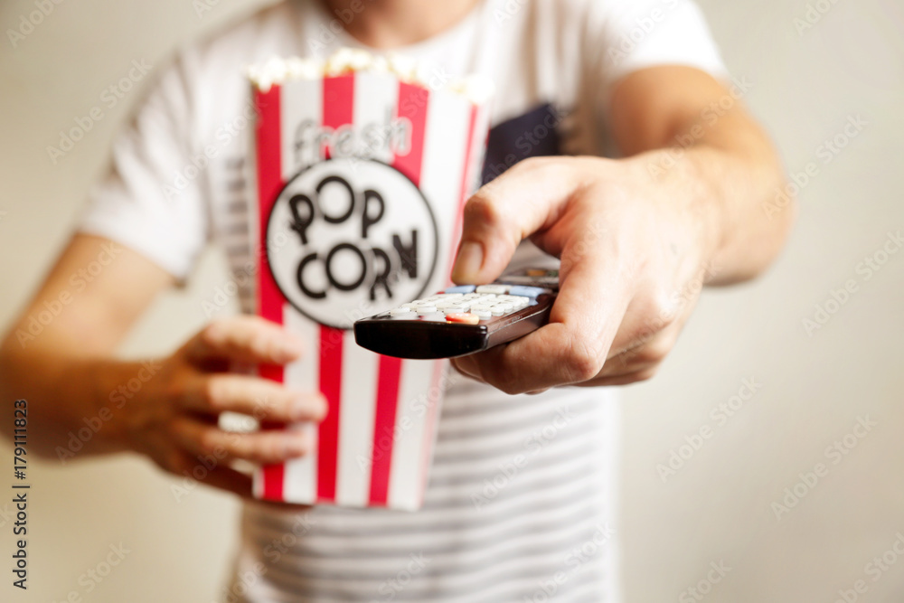 Remote control and box of fresh popcorn Remote control and box of fresh popcorn