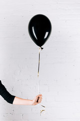 person holding black balloon
