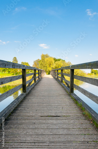 Fototapeta Naklejka Na Ścianę i Meble -  boardwalk with handrails over calm lake with trees