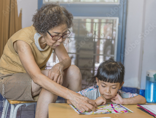 Grandmother teach reading grand daughter. Real situation