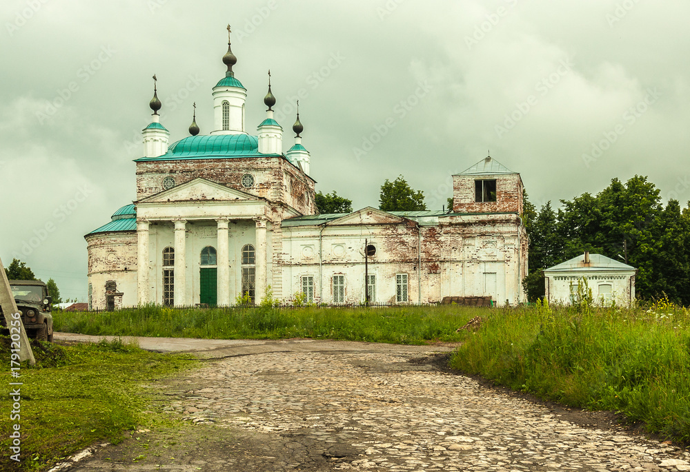 A Russian Orthodoxal church on a hill in a tiny town, The church is shabby but working.