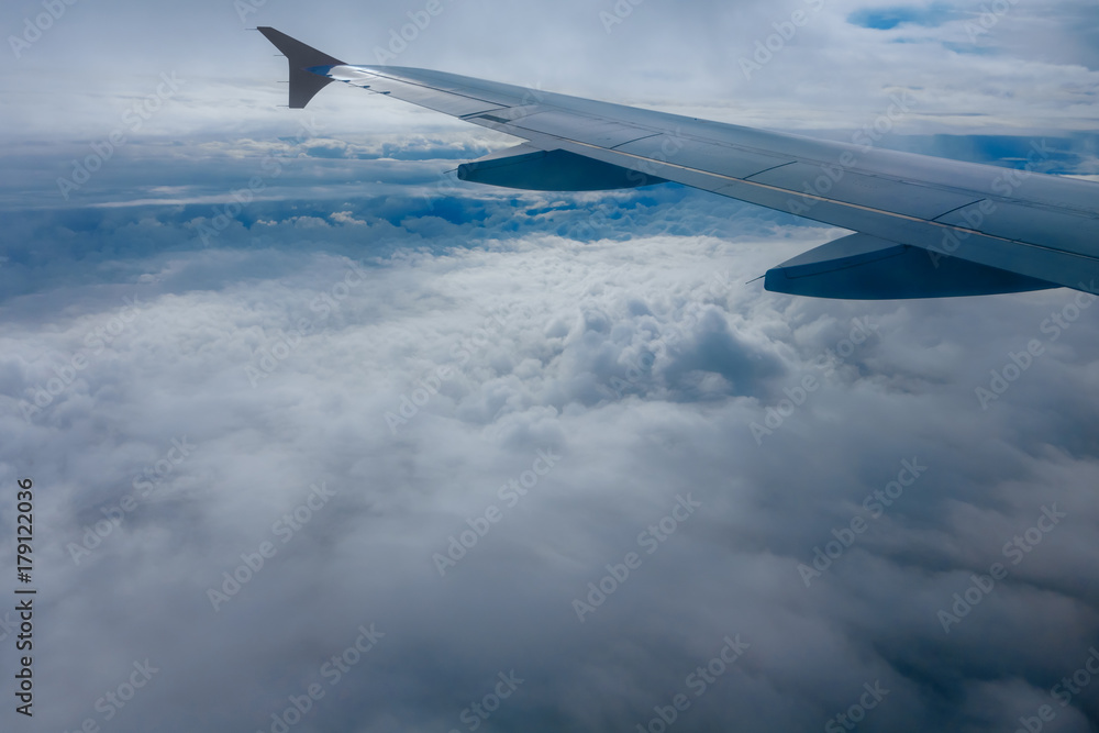 Obraz premium Wing of flying airplane in the clouds