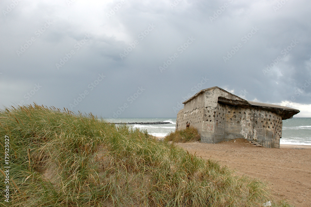 Remains of the Atlantic Wall at the beach of Thyboroen in Denmark. Built during WW2 the bunkers still stand visible and illustrates the former defense line. Remains of the Atlantic Wall at the beach of Thyboroen in Denmark. Built during WW2 the bunkers still stand visible and illustrates the former defense line.
