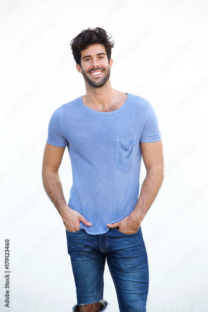 Fototapeta premium Smiling handsome man standing isolated on white wall