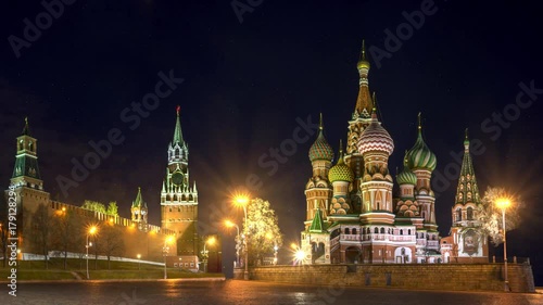 Intercession Cathedral (St. Basil's) and the Spassky Tower of Moscow Kremlin at Red Square in Moscow. Russia. Night illumination and snow falling.