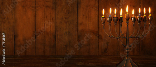 ewish holiday Hanukkah background with traditional spinnig top, menorah (traditional candelabra) and burning candles photo