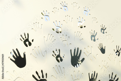 Handprints, adults and children's palms make a natural pattern on a white wooden background. The concept of friendship and art