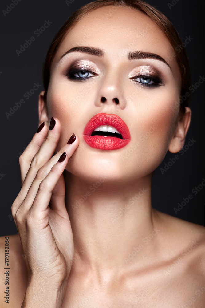 Portrait of beautiful girl model with evening makeup and romantic hairstyle. Touching her red lips Portrait of beautiful girl model with evening makeup and romantic hairstyle. Touching her red lips