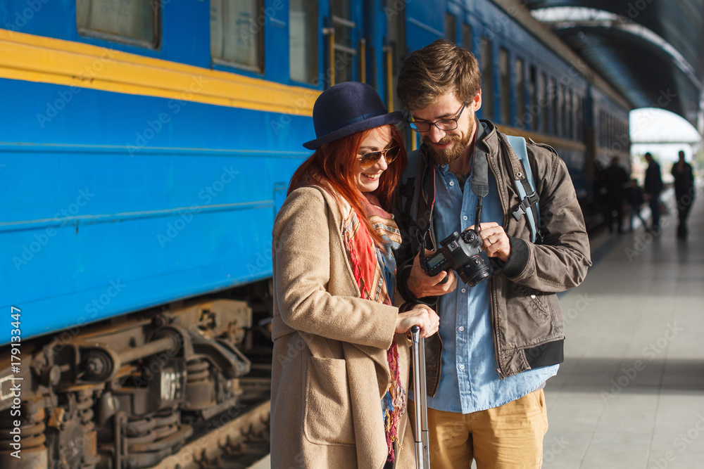 Portrait of young travelling couple looking at the photos. Tourism concept