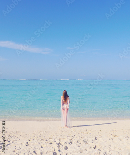Beautiful sexy woman in a swimsuit posing on a beach at summer. Holidays vacation, luxury resort. Woman enjoying a walk on the white sand beach on sunny day. Sexy caucasian woman on tropical beach.