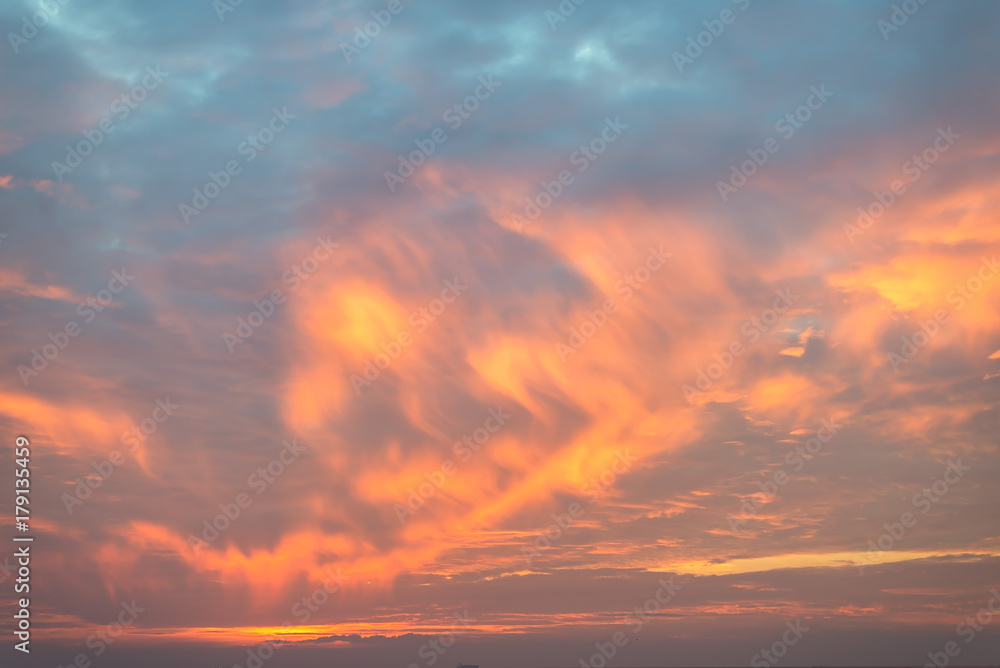 The sunrise dramatically illuminates the clouds with color.