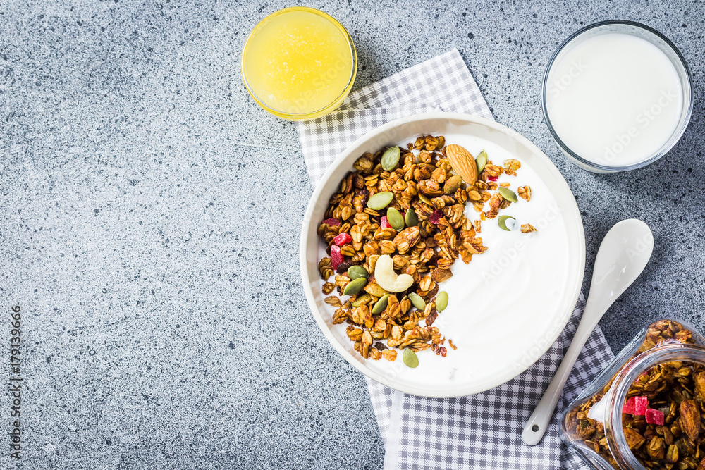 Healthy high protein grain free granola yogurt breakfast on dark concrete background. Top view, space for text. Healthy high protein grain free granola yogurt breakfast on dark concrete background. Top view, space for text.
