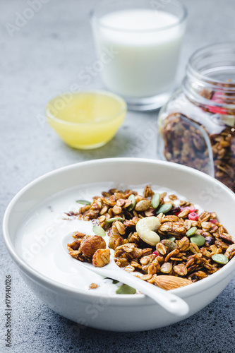 Healthy vegan granola yogurt breakfast on dark concrete background. Selective focus, copy space.