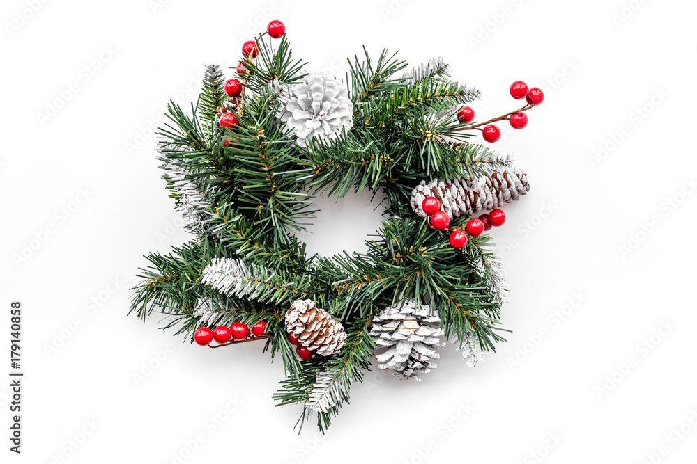 Christmas wreath woven of spruce branches with red berries on white background top view Christmas wreath woven of spruce branches with red berries on white background top view