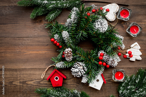 Christmas decorations. Wreath and toys on wooden background top view copyspace