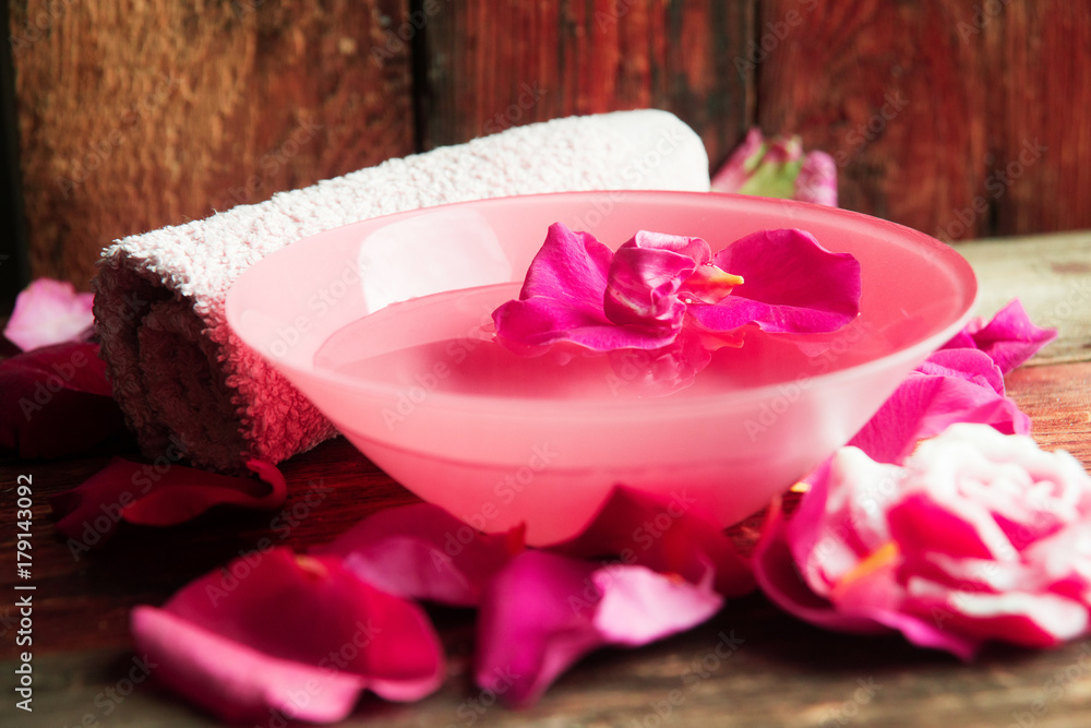 Spa setting with rose pink flowers and petals,bath salt and body-oil Spa setting with rose pink flowers and petals,bath salt and body-oil