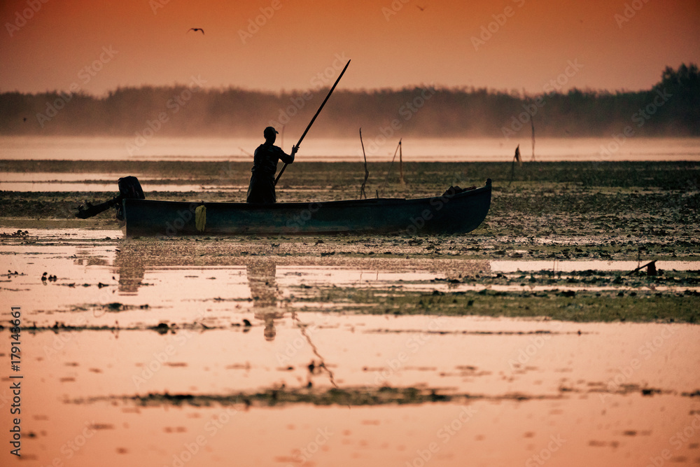 Traditional fisherman catching fish at sunrise in Delta Dunarii, Romania