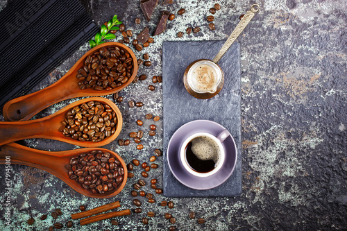 Black coffee in a cup on the background of coffee beans in a composition with accessories photo