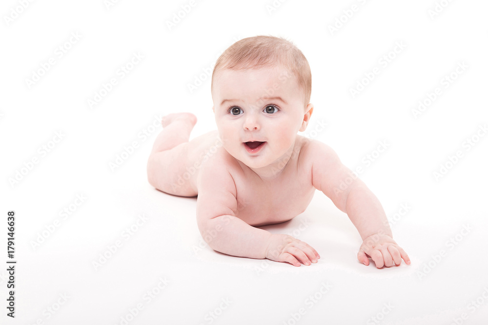 Naked smiling baby lying on his stomach on a white background and looking at the camera Naked smiling baby lying on his stomach on a white background and looking at the camera