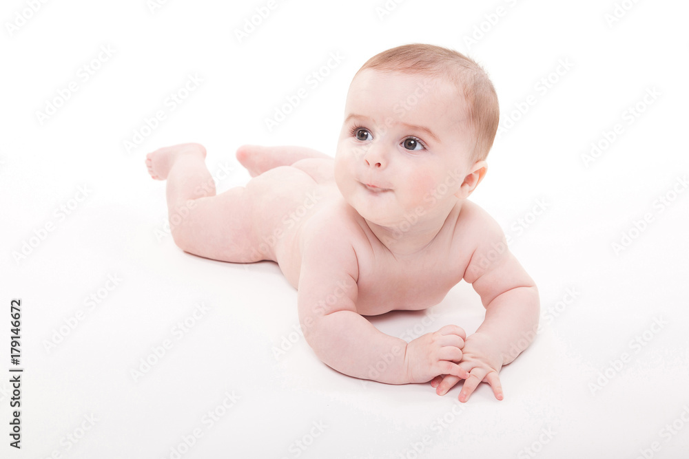 Naked smiling baby lying on his stomach on a white background and looking at the camera Naked smiling baby lying on his stomach on a white background and looking at the camera