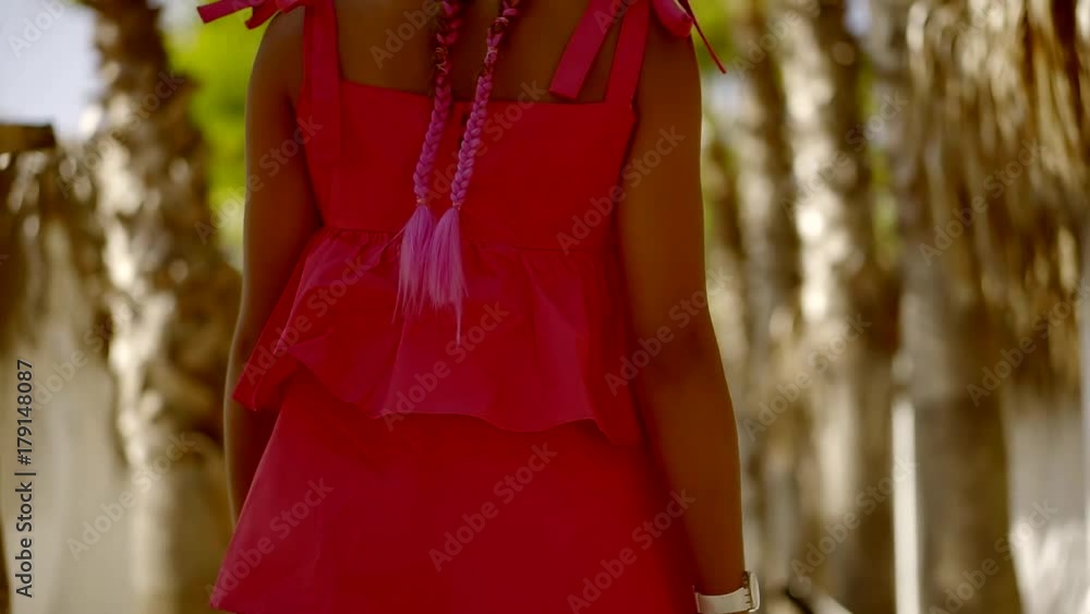 camera is following beautiful girl is moving along old palms trees in a tropical garden, is turning camera is following beautiful girl is moving along old palms trees in a tropical garden, is turning