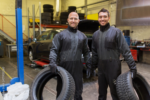 auto mechanics changing car tires at workshop