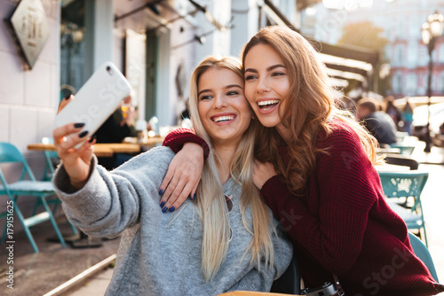 Two happy smiling girls taking a selfie