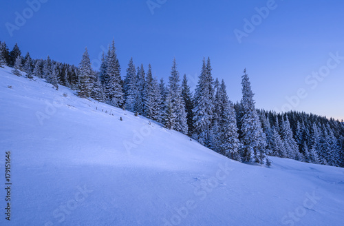 Winter landscape of a mountain slope at sunset. © ianachyrva