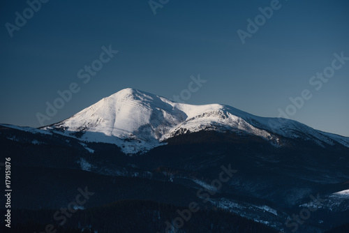 Winter landscape of a mountain range covered with snow. Mountain range at the sunrise