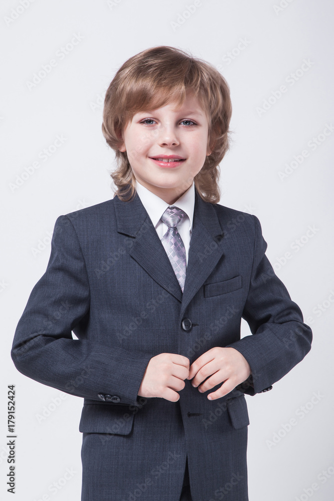 child in a classic suit straightens his jacket child in a classic suit straightens his jacket