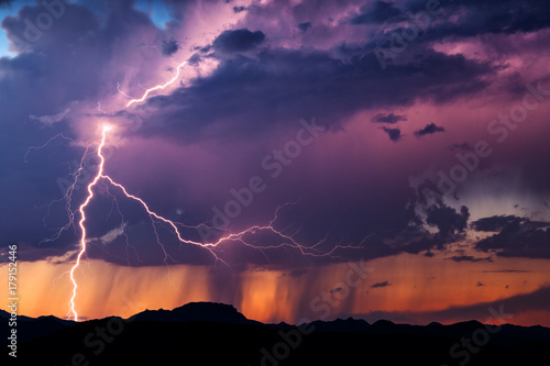Lightning illuminates a thunderstorm at sunset