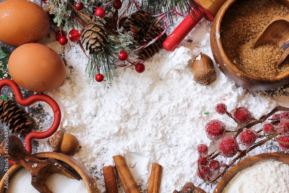 Christmas baking cake background. Ingredients and tools for baking - flour,  eggs, silicone molds in the shape of a Christmas tree, and a rolling pin on  a wooden background. Stock Photo