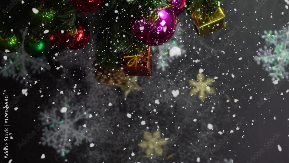 Greeting Season concept. Hand setting of Christmas tree and decorations with presents and ornaments on white wood table from above with falling snow in 4k (UHD) Greeting Season concept. Hand setting of Christmas tree and decorations with presents and ornaments on white wood table from above with falling snow in 4k (UHD)