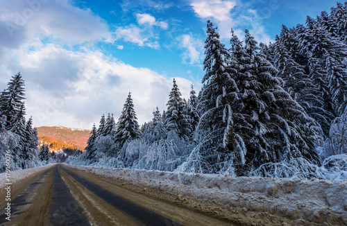snowy road through mountains in evening. wonderful nature scenery in winter