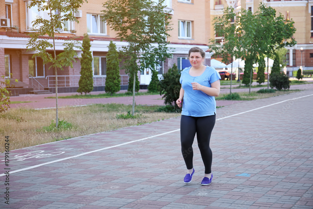 Overweight woman running, outdoors