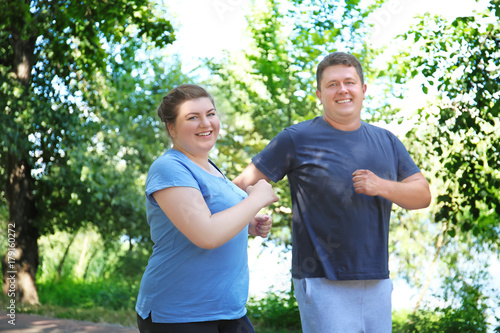 Overweight couple running in green park