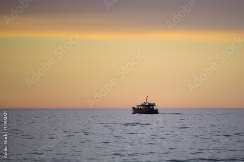 Statek na tle zachodu słońca na plaży nad morzem. © Rajtar photography