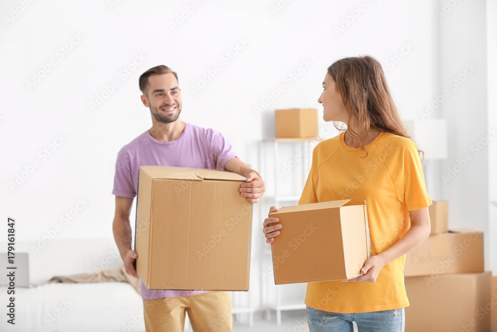 Young couple with moving boxes at new home Young couple with moving boxes at new home