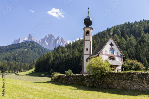 The Johanneskapelle (St. Johann in Ranui), a chapel in Villnoss (Val di Funes) with the Geisler group of mountains of the northwestern Dolomites in the background. South Tyrol, northern Italy