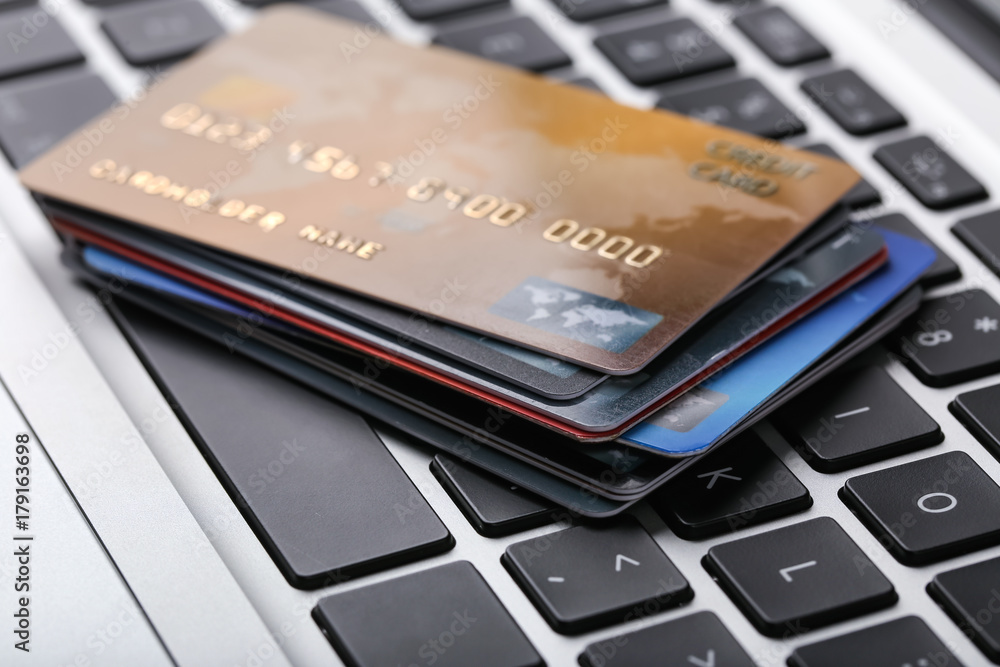 Credit cards on laptop keyboard, close up Credit cards on laptop keyboard, close up