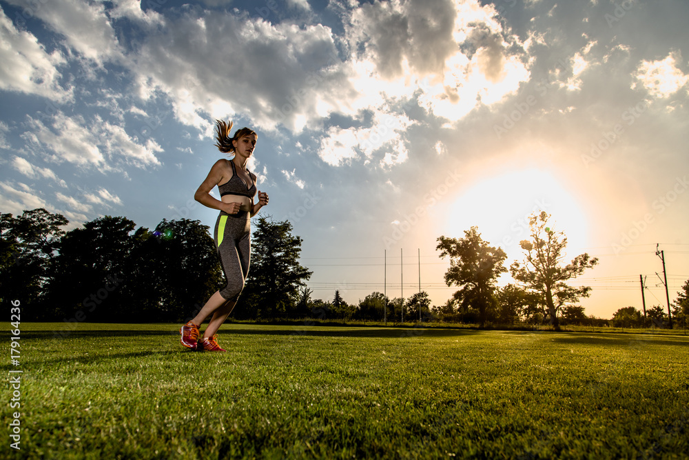 Wide angle picture of running women with sun in background