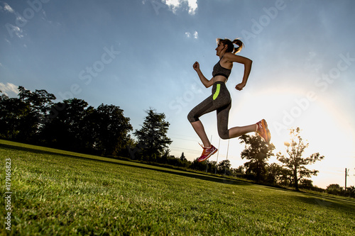 Wide angle picture of running women with sun in background