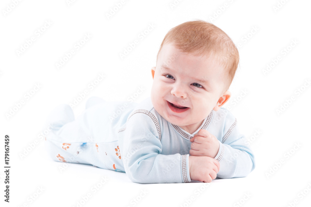 cute pretty baby boy in blue pijamas lies on tummy