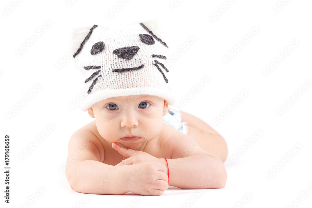 cute attractive baby boy in diaper and cat hat lies on tummy
