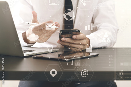 close up of businessman working with smart phone on wooden desk in modern office with virtual icon diagram