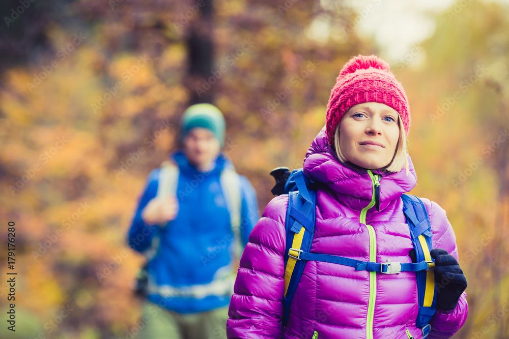 Man and woman happy couple hikers walking in autumn woods Man and woman happy couple hikers walking in autumn woods