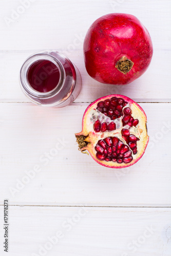 Fototapeta Naklejka Na Ścianę i Meble -  Pomegranate and juice in glass on white wooden background