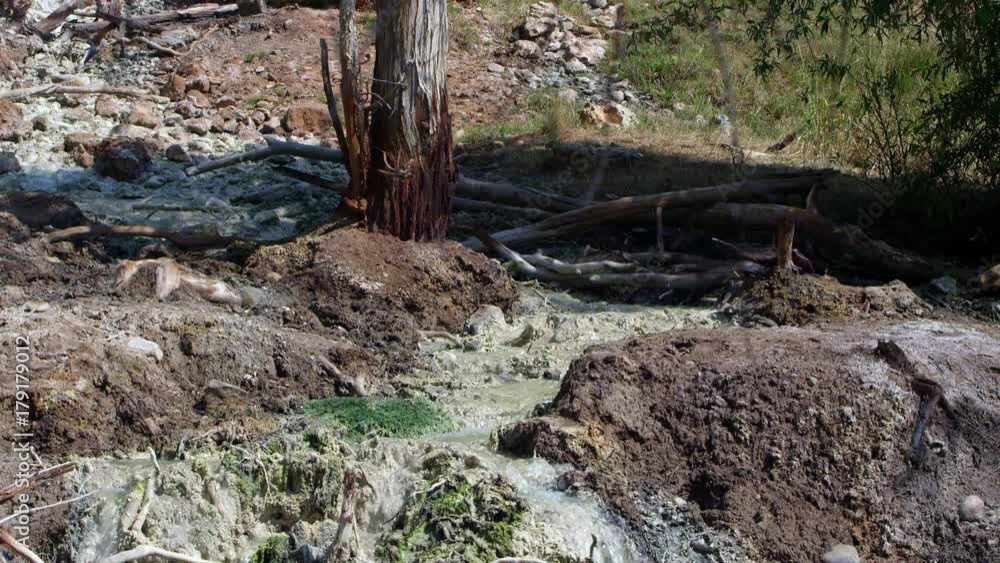 View of hot spring flowing downstream to river from hillside. View of hot spring flowing downstream to river from hillside.